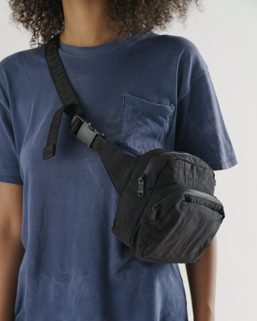 Woman with a blue t-shirt wearing a black fanny pack