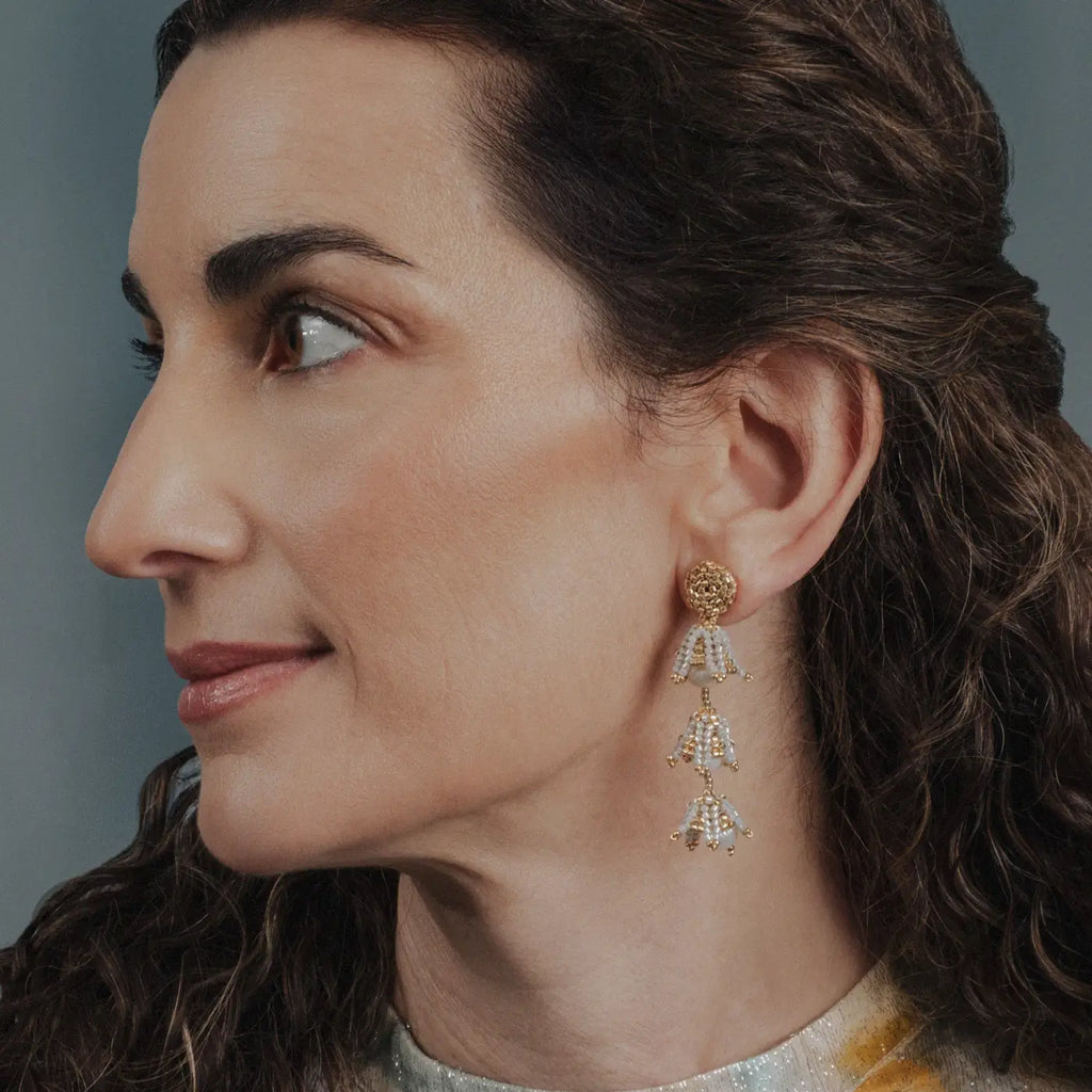 side view of woman wearing gold and pearl beaded earrings