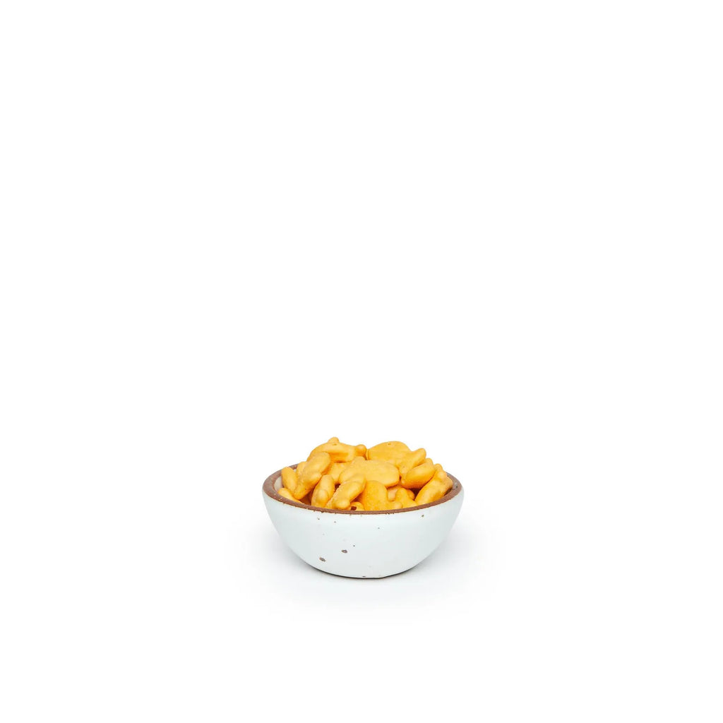 small eggshell colored clay bowl with orange goldfish crackers in it