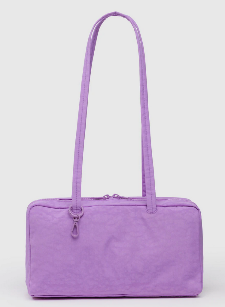 Purple handbag with a strap on a light gray background