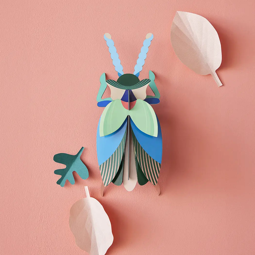 studio roof emerald colored beetle wall art puzzle on peach background with leaves