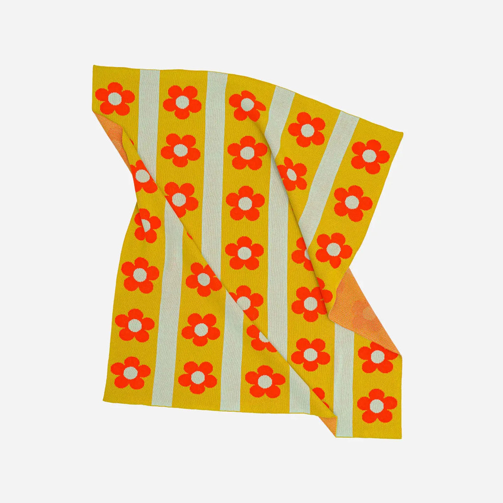 Knit throw with red floral pattern on yellow and white striped background