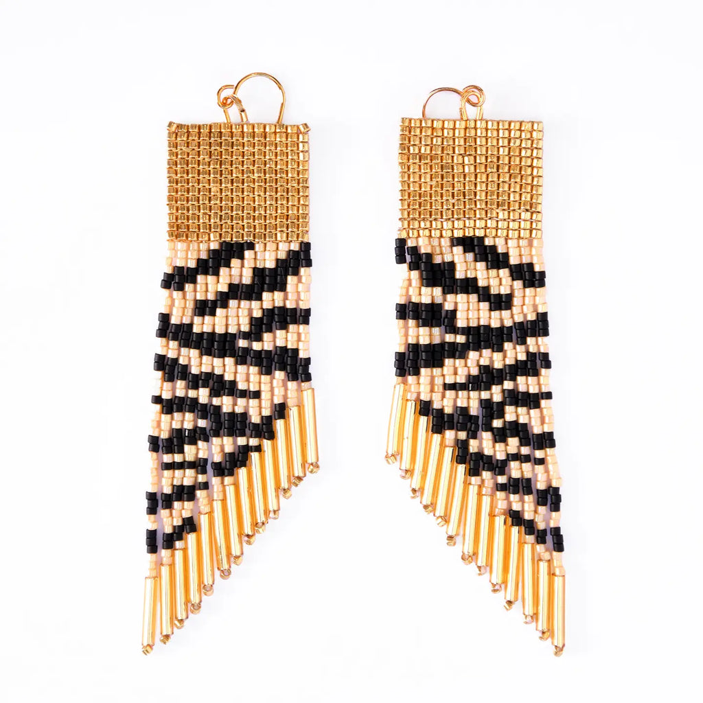 Pair of zebra stripe beaded earrings with gold and black fringes on a white background