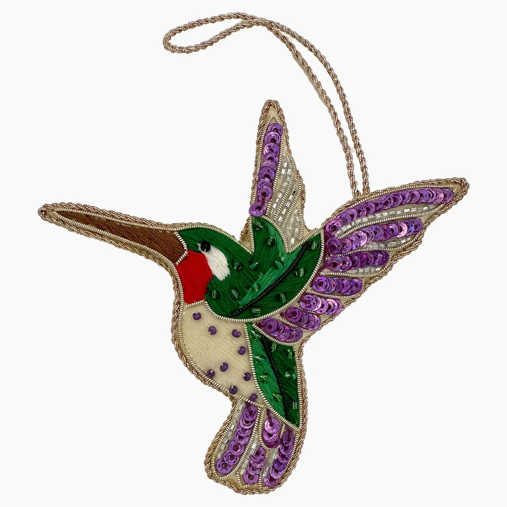 Decorative hummingbird ornament with sequins on a white background