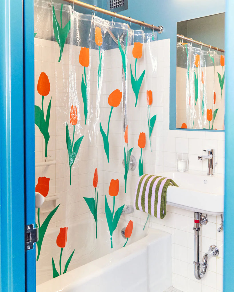 Bathroom with a red tulip floral-patterned shower curtain and blue walls.