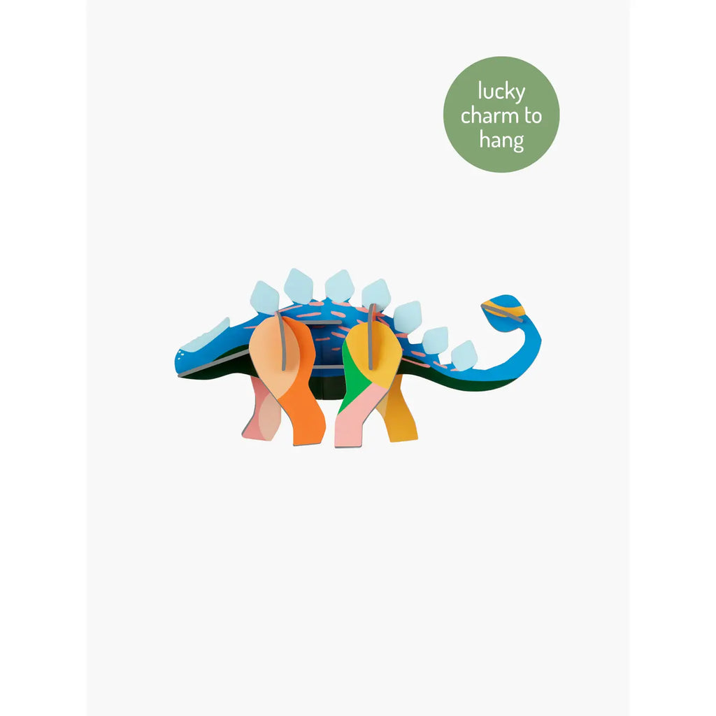 Colorful dinosaur-shaped charm with 'lucky charm to hang' text on a white background