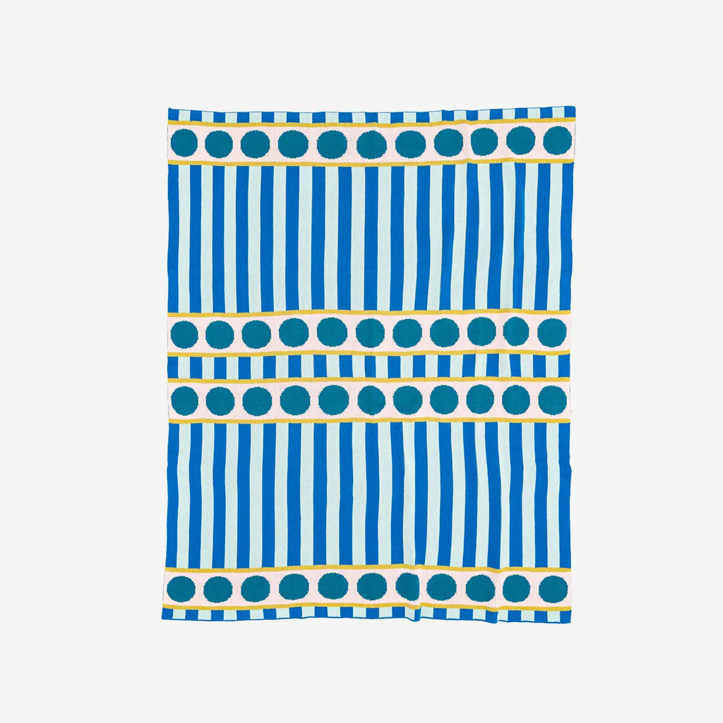 Knitted stripe dot throw in cobalt against a white background.