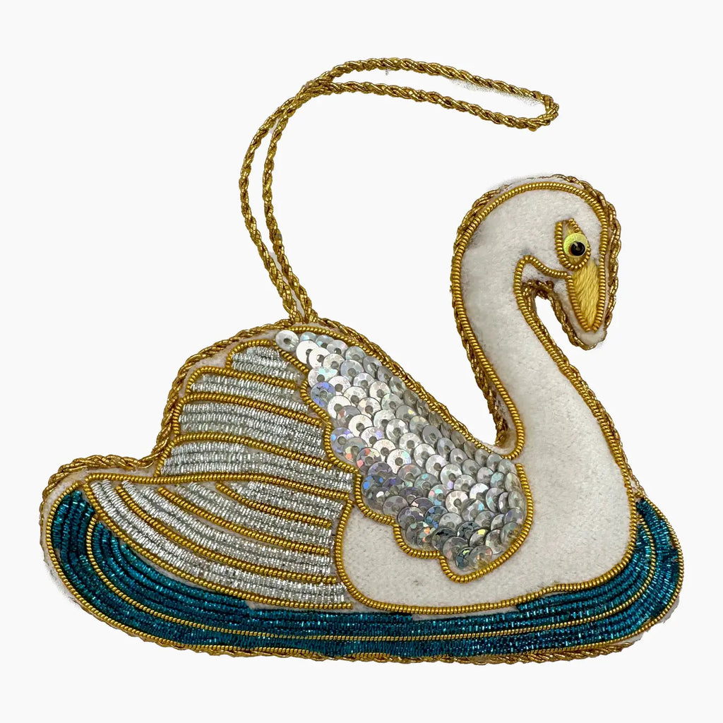Decorative swan ornament with sequins and beads on a white background