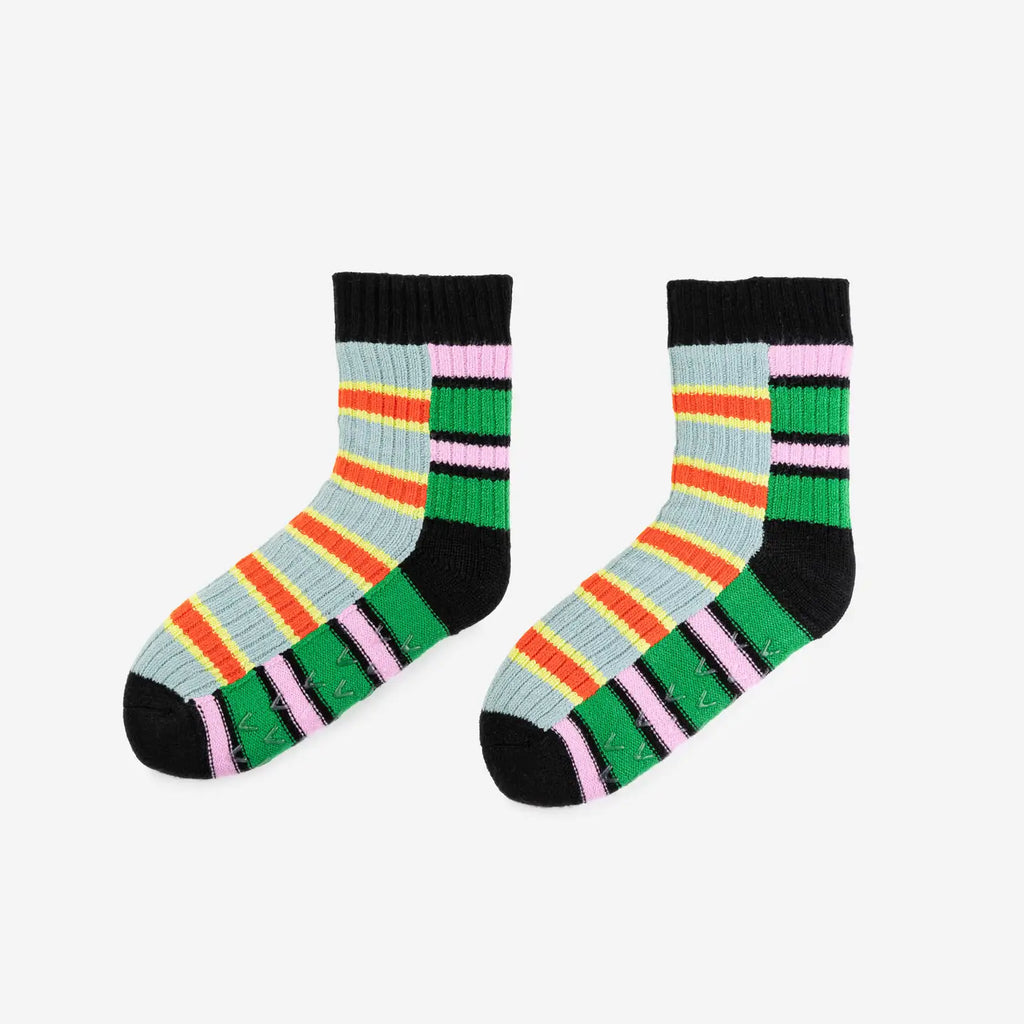 Colorful orange, grey, pink, green and black striped socks on a light gray background