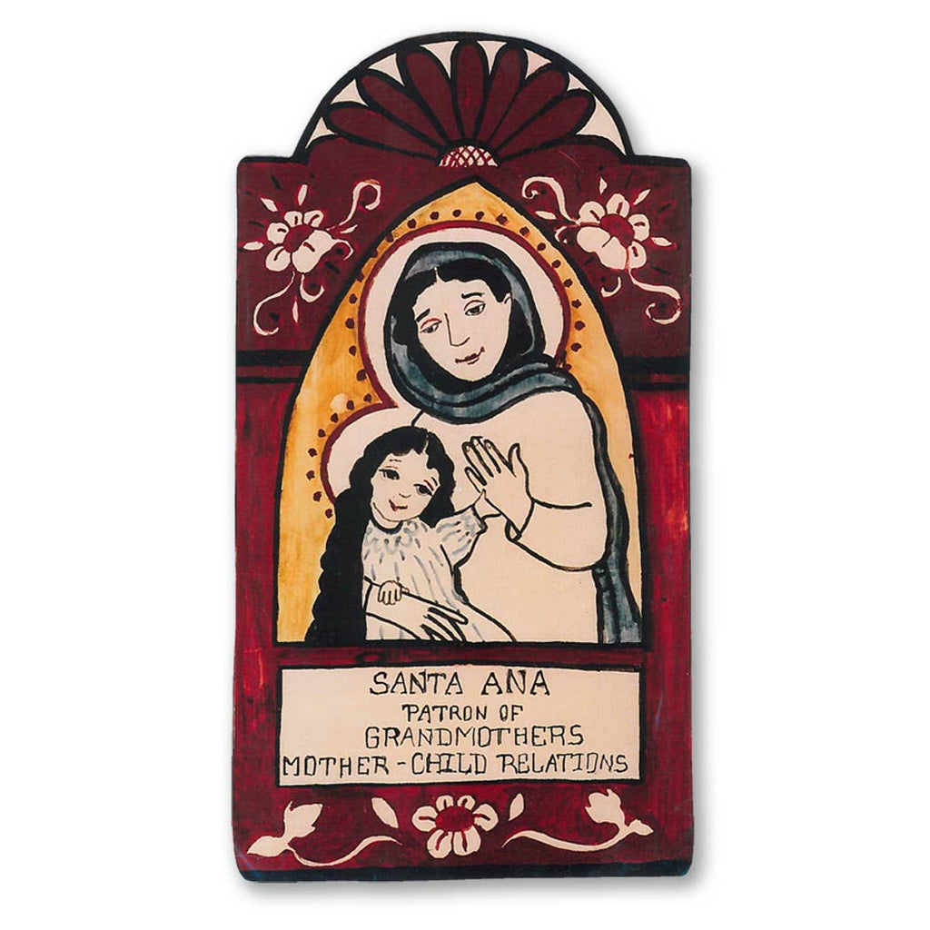 A religious pocket saint retablo featuring Santa Ana, a figure representing grandmother and mother-child relationships, with a red background and a symbolic depiction of a mother holding a child.