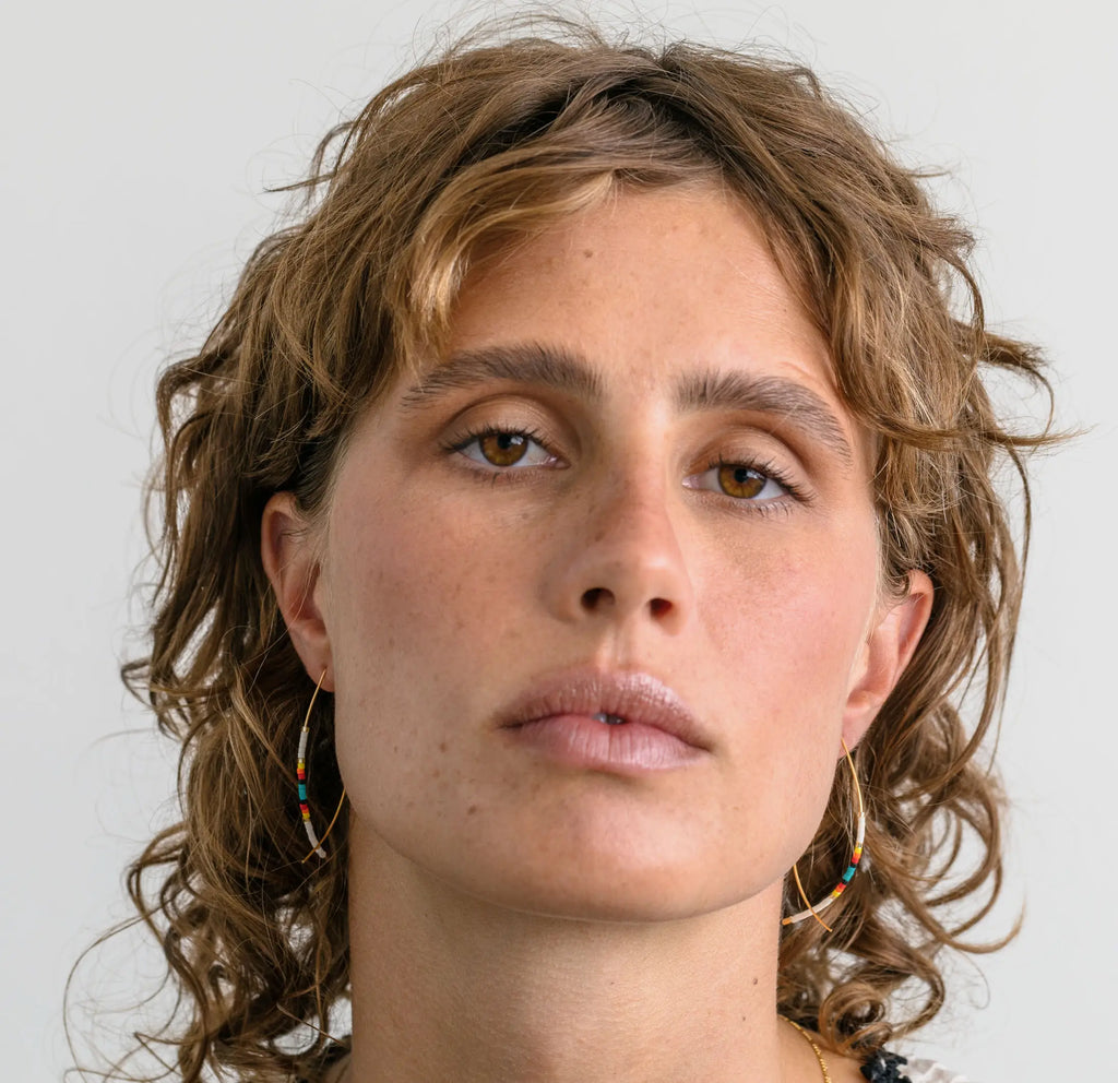 woman with brown hair wearing beaded earrings