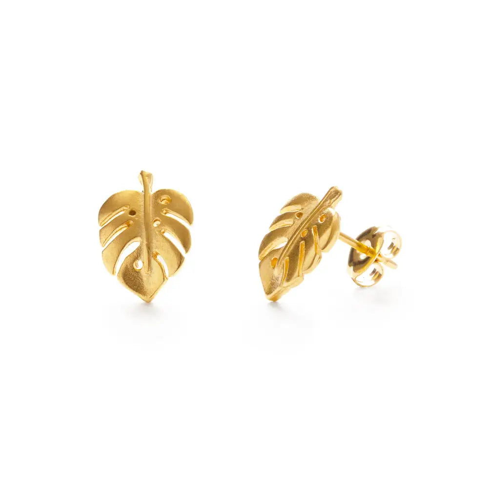pair of gold stud earrings shaped like a monstera plant leaf, made in the USA