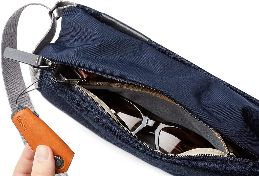 navy mini-sling bag unzipped with key fob